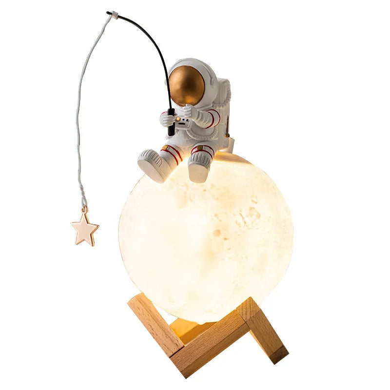 Gold resin astronaut figurine humidifier night light with wood base, 28 cm tall, on a desk