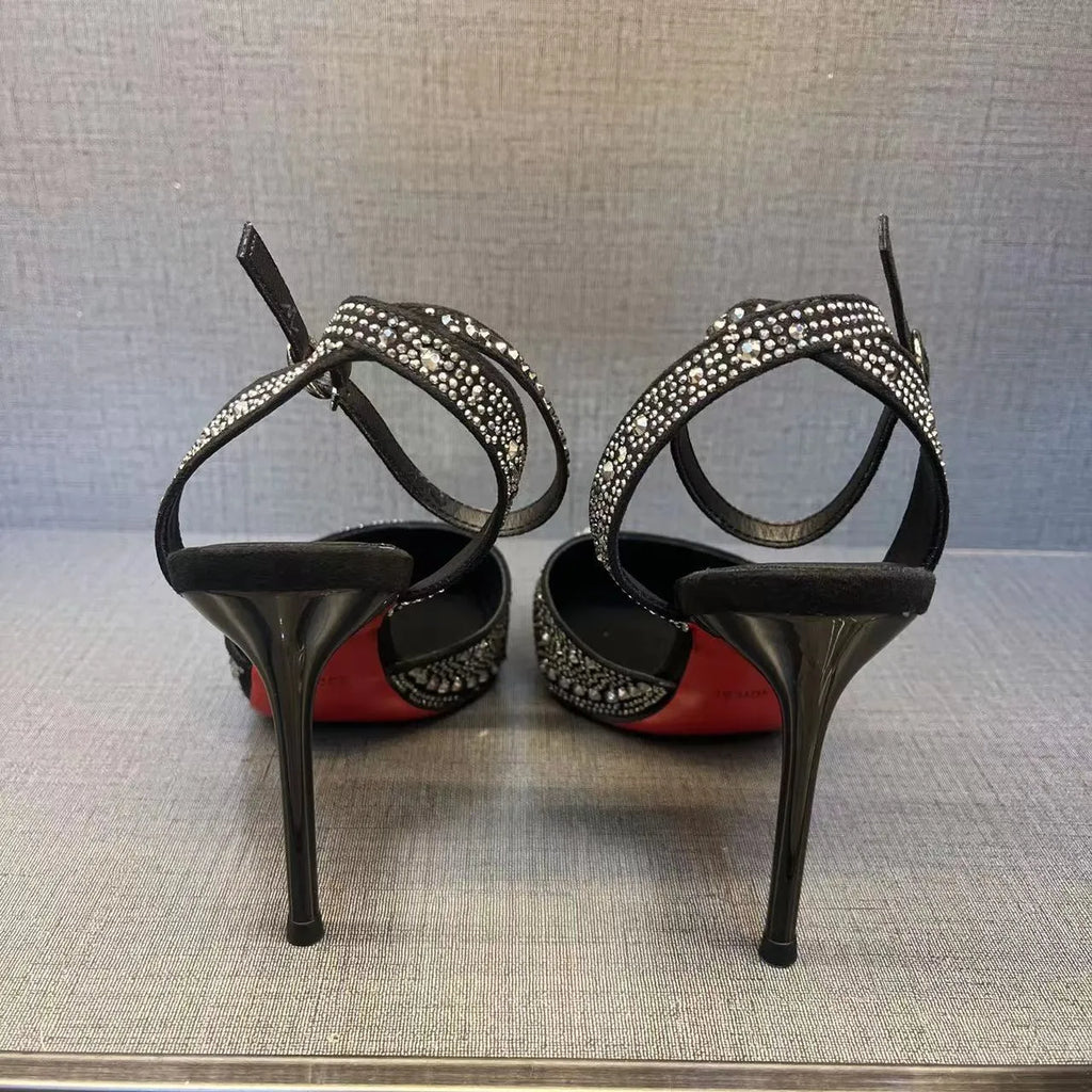 Women's black high heels with hollow stiletto heel, pointed toe, and a bright red sole.