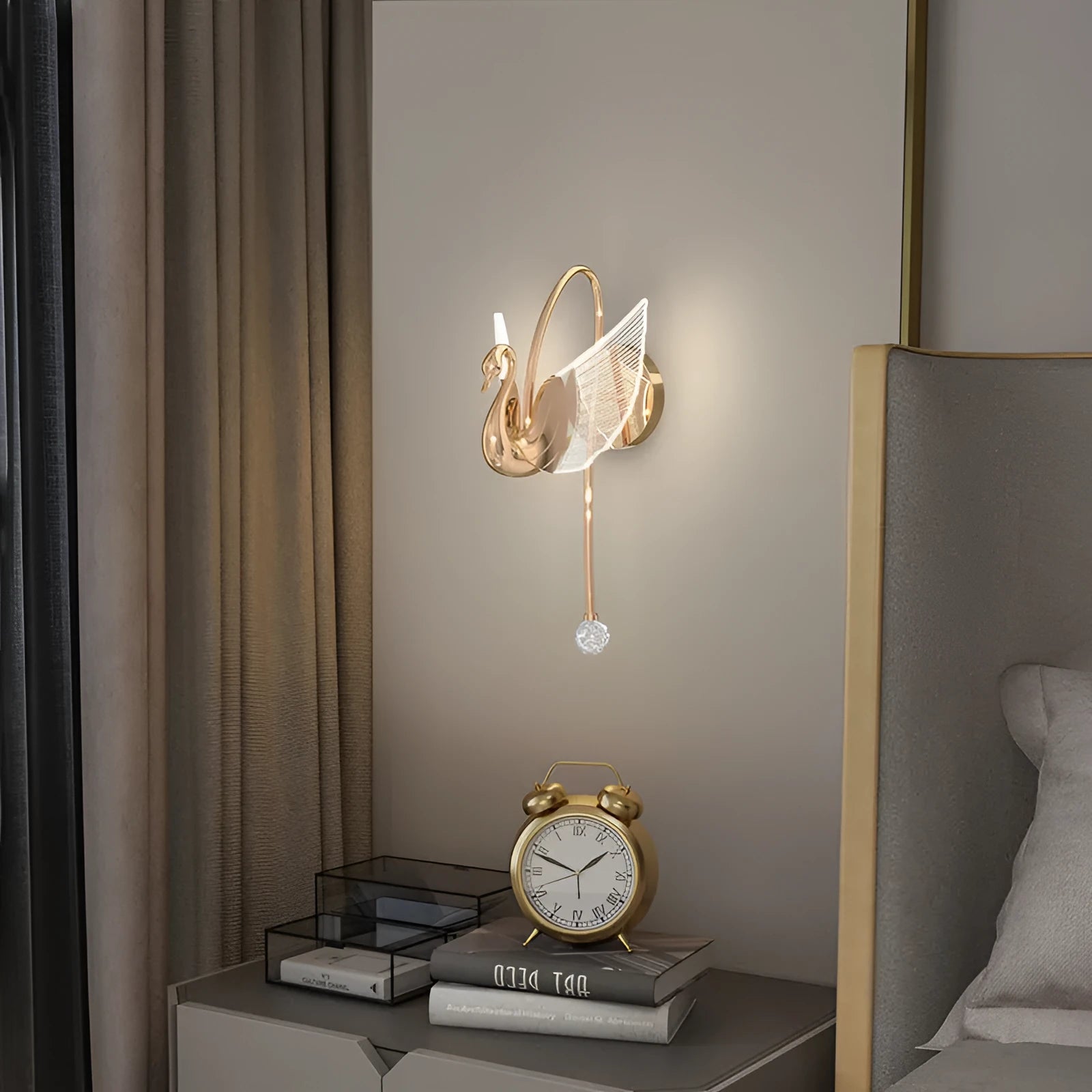 Gold minimalist swan-shaped wall lamp with an acrylic shade mounted on a wall.