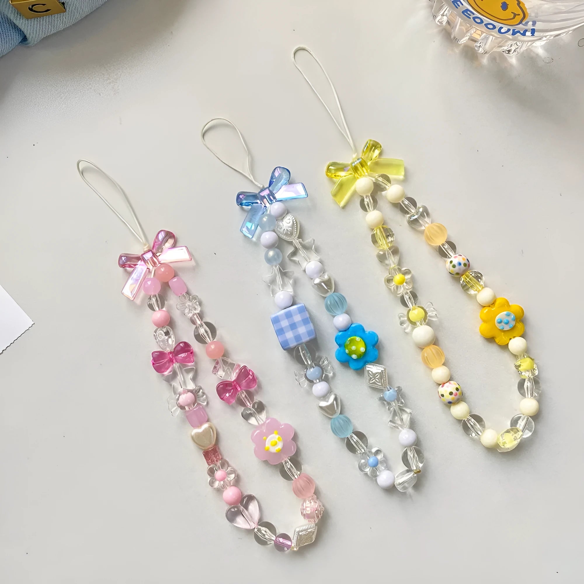 Beaded flower phone lanyard with plastic resin beads on adjustable cord in yellow, blue or pink