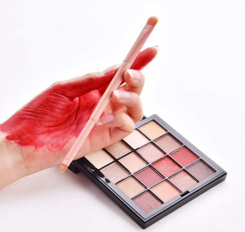 Ten professional makeup brushes with pink painted wooden handles and nylon bristles, including powder, foundation, and double-ended brushes.