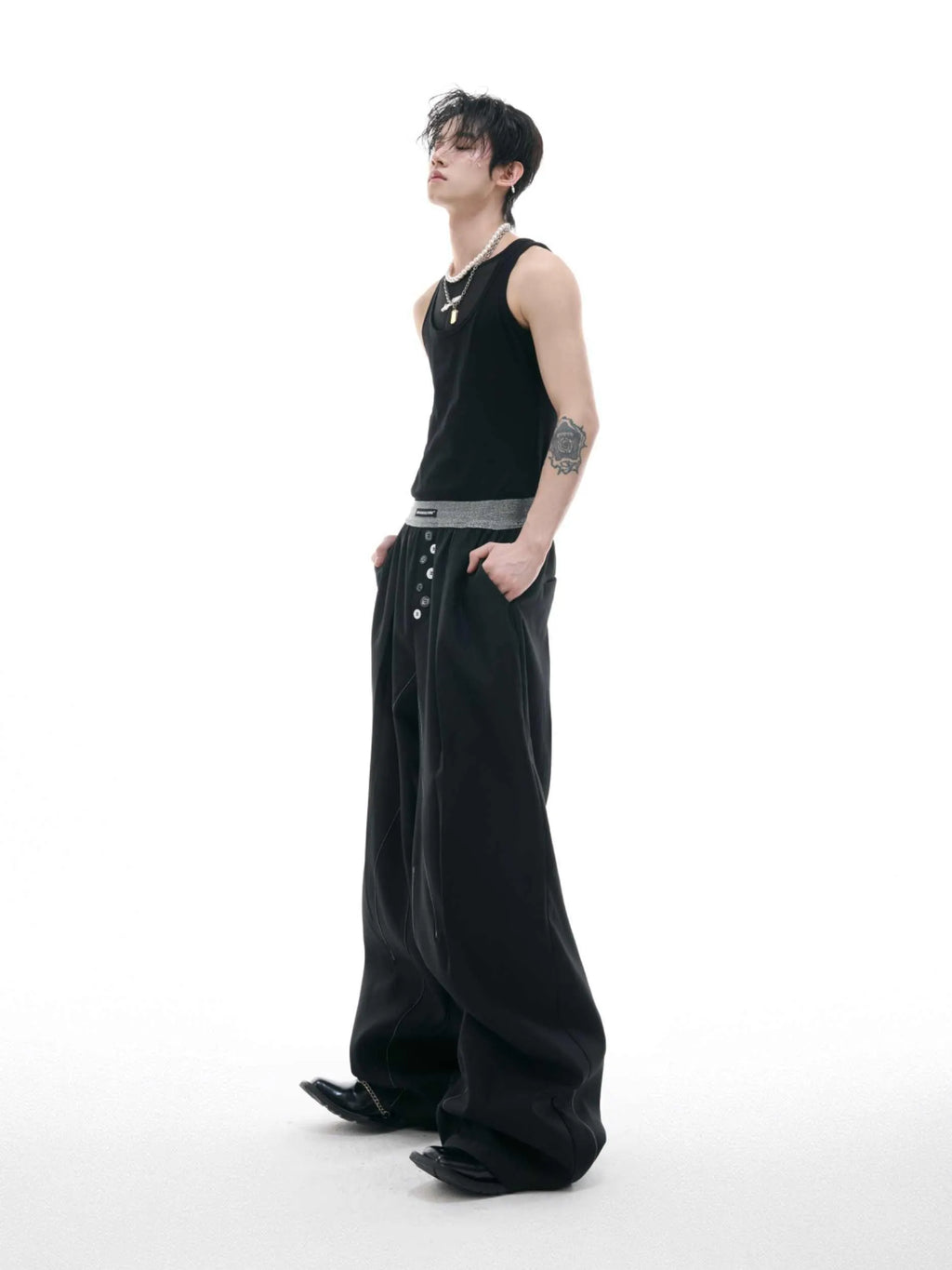 High-waisted drooping straight-leg trousers in black with button open line design detail.