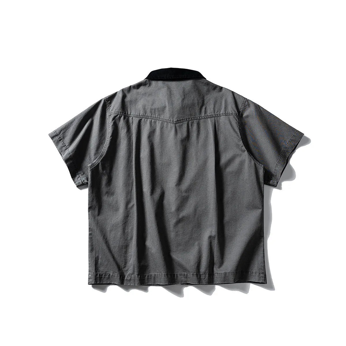 Washed khaki cotton overalls shirt with short sleeves and loose cardigan style on a hanger