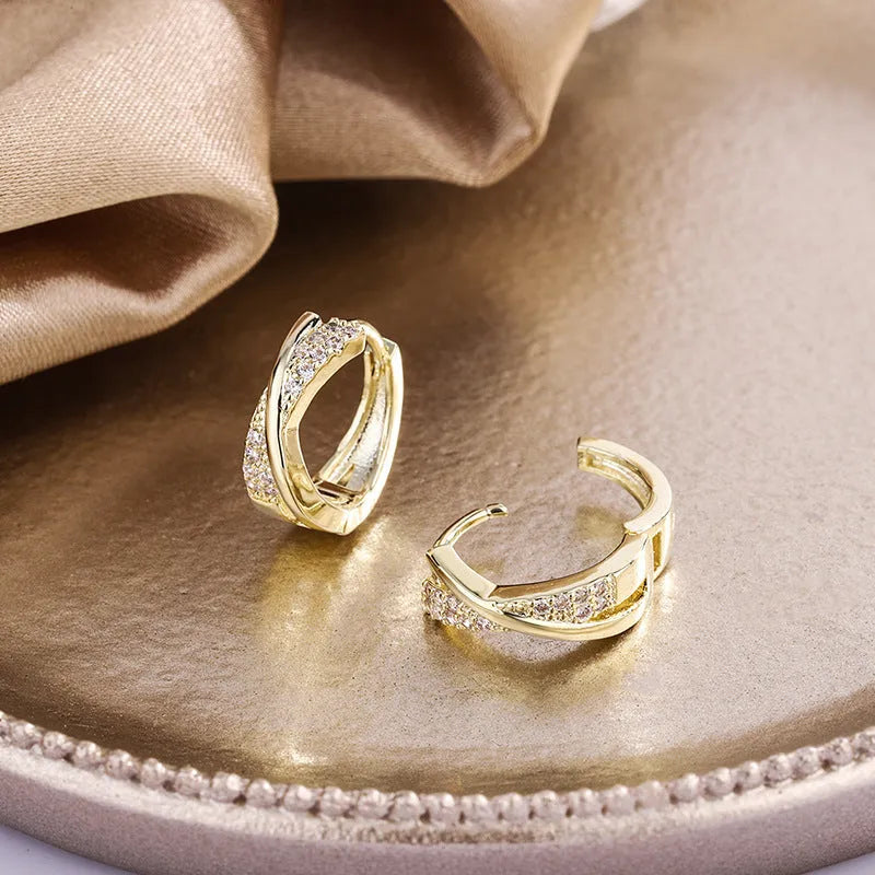 A pair of 14K yellow geometric shaped stud earrings on a plain background.