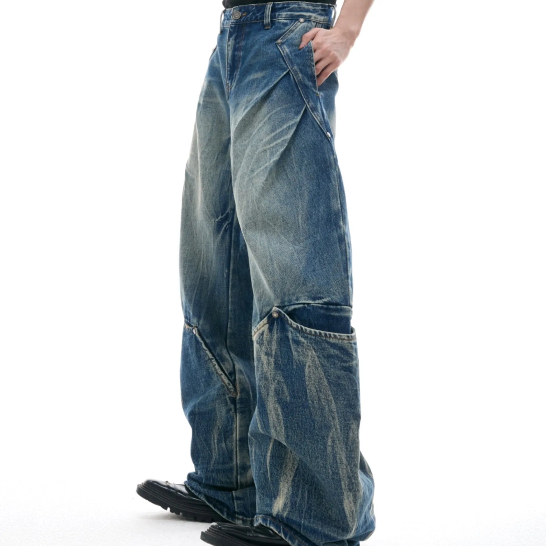 Men's verdant blue loose fit jeans with a retro washed burst pattern and curved knife design details.