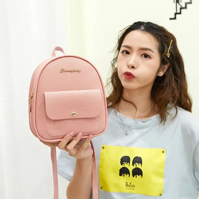 Small black PU women's backpack purse shown as a shoulder bag, with zipper closure and compact size.