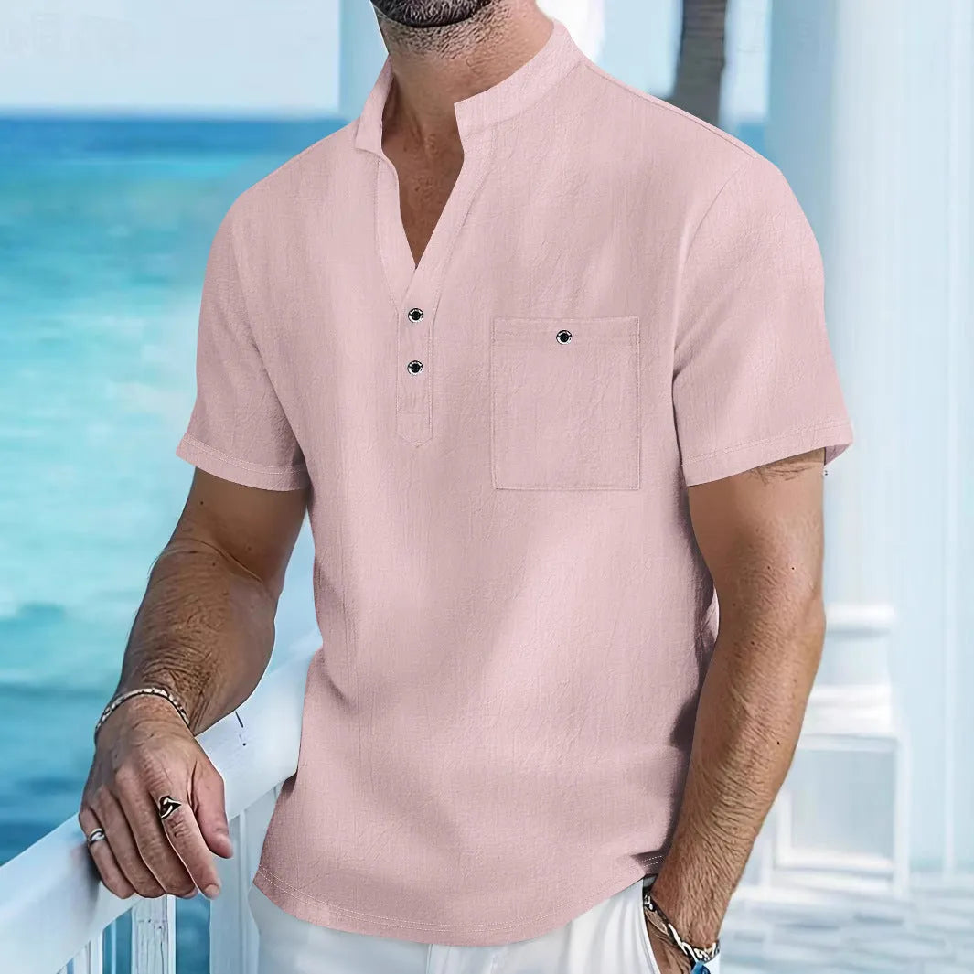 Man wearing a light apricot-coloured linen short sleeve shirt with a stand collar.