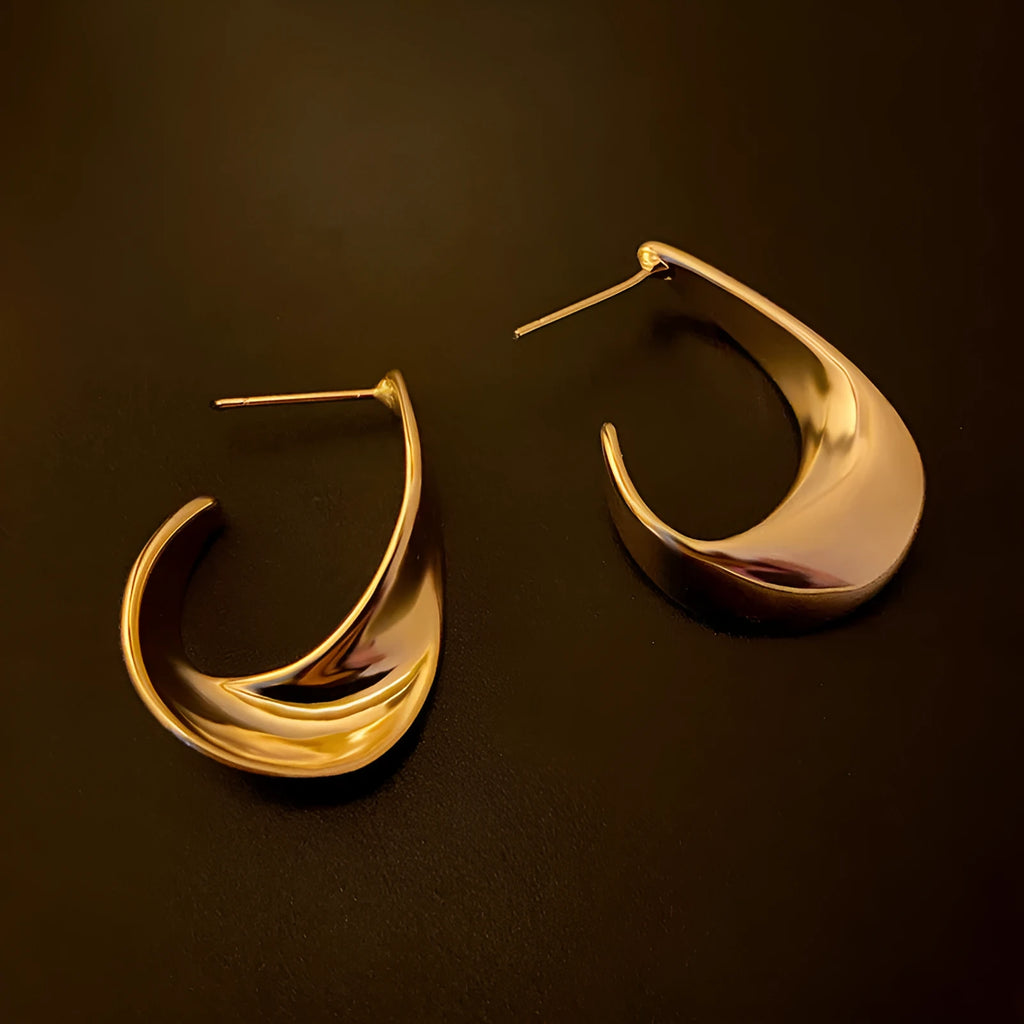 Gold and silver geometric twisted metal earrings with round design elements