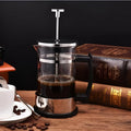 Compact glass and stainless steel manual pour-over coffee maker with 350ml capacity.