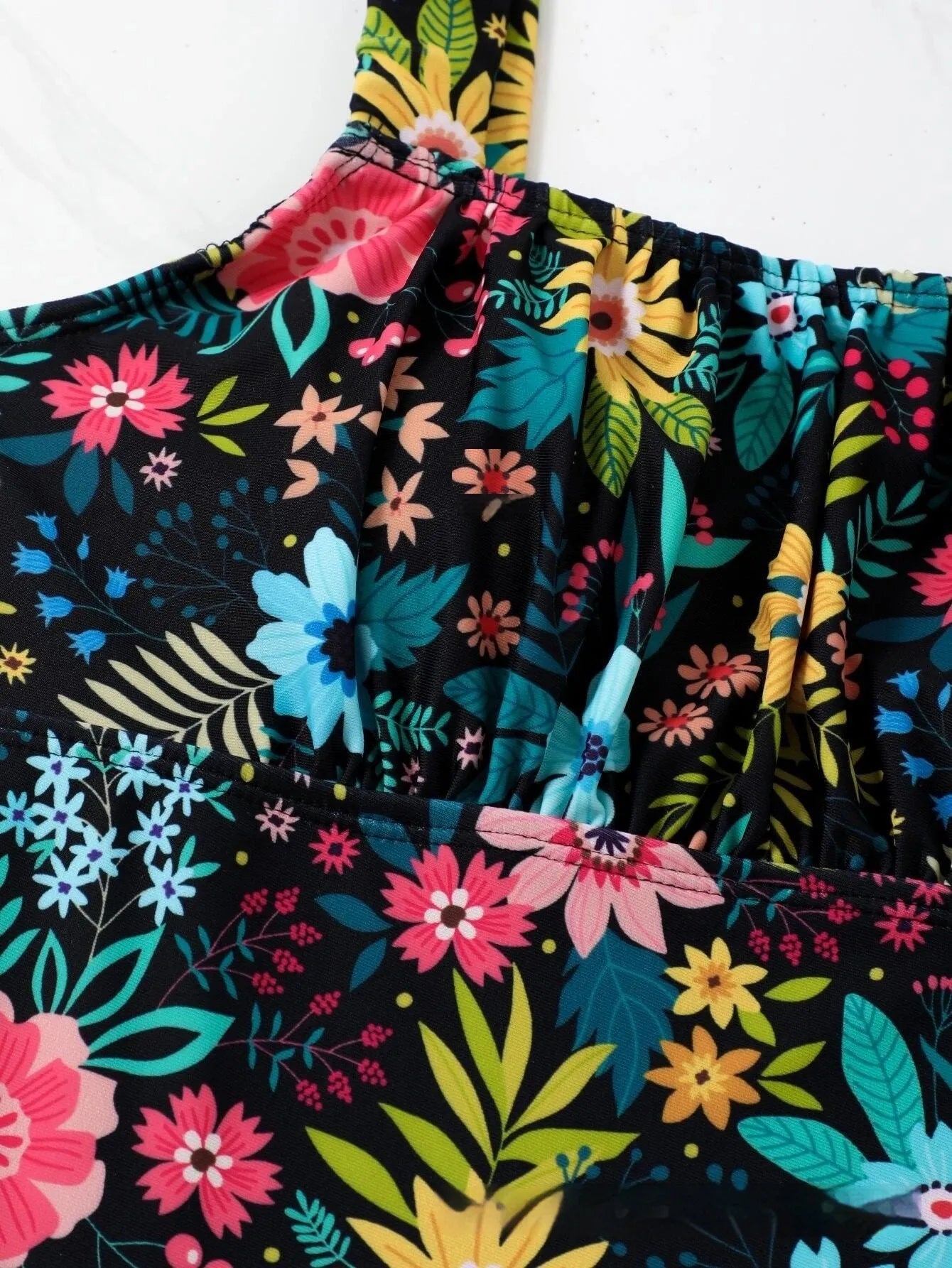Women's floral print one-piece swimsuit showing full coverage design and pastoral pattern
