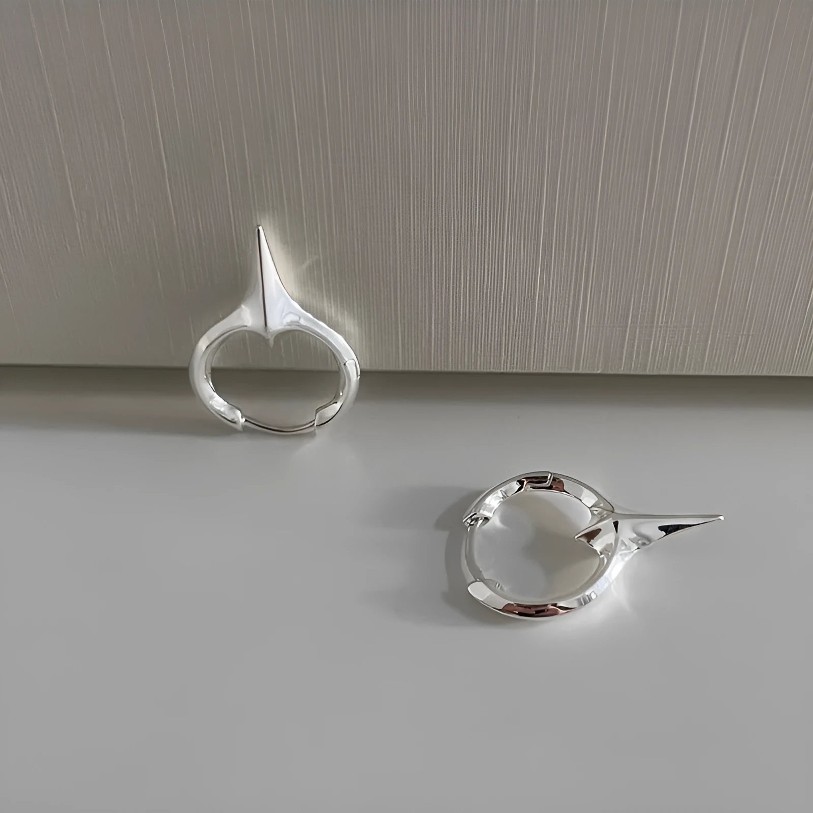 A pair of platinum-coloured geometric star-shaped clip-on earrings for women, made from electroplated copper.