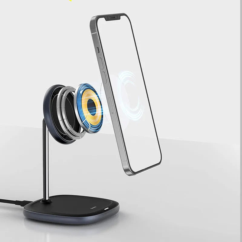 Black Swan magnetic wireless charging stand holding an iPhone 12 upright on a wooden desk.