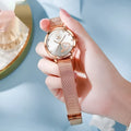 Women's rose gold fashion watch with mesh strap showing colour options: black, blue, green, pink, red, white face.