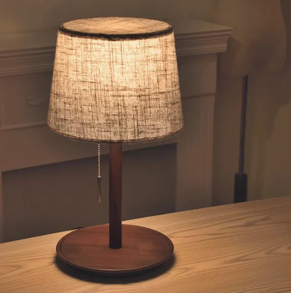 Walnut-colour solid wood bedside lamp with white cloth shade and cable switch