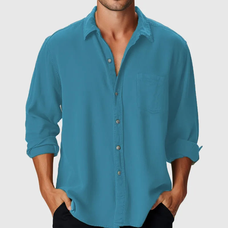Man wearing a loose-fitting light blue polyester holiday shirt with a stand collar and long sleeves.