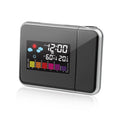 Black digital projection alarm clock with multicolour LED display on a bedside table.