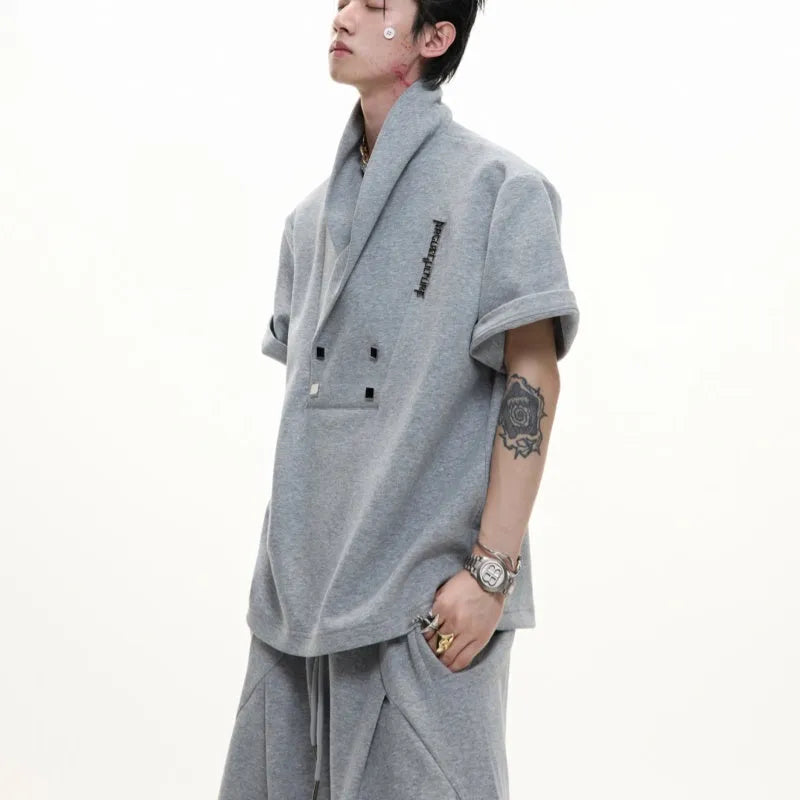 Men's dark grey V-neck sports jacket with padded shoulders and metal details paired with matching shorts