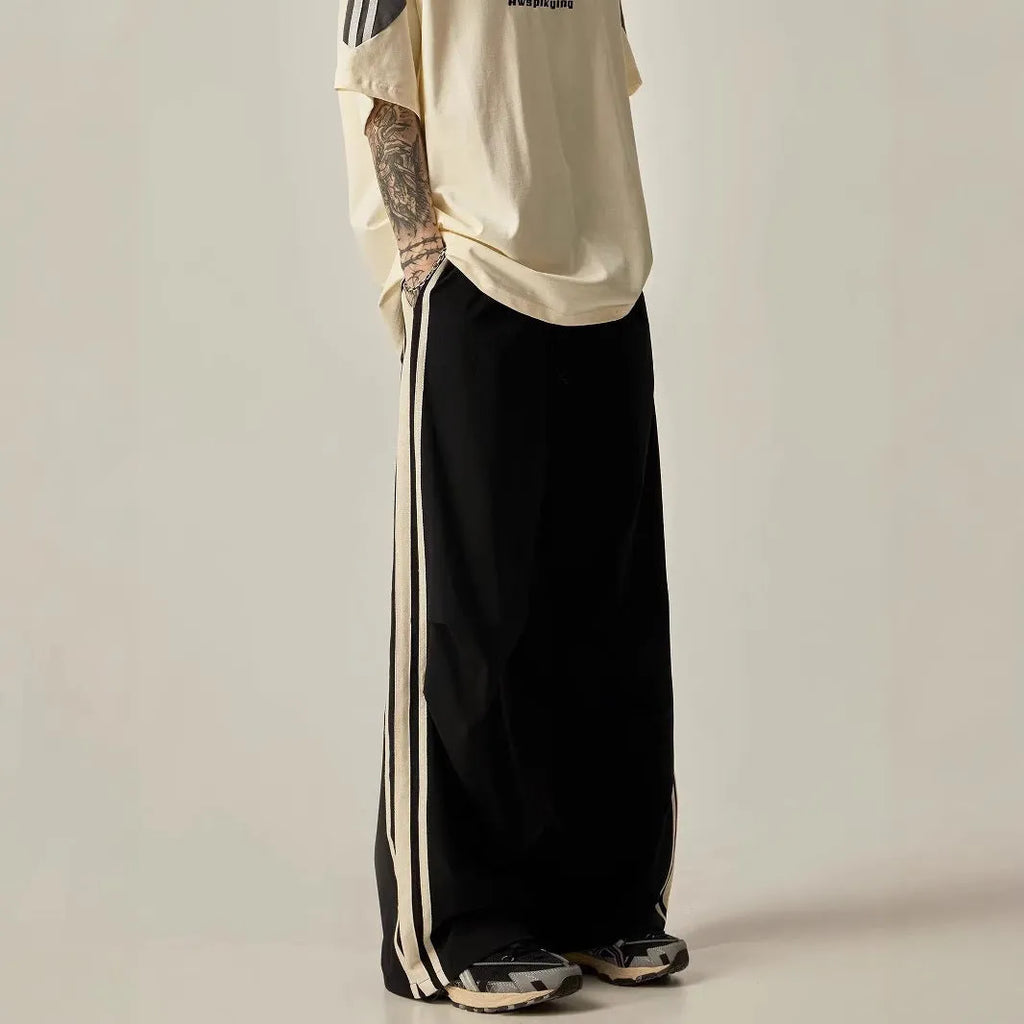 Man wearing black high-waist wide-leg climbing trousers in a casual setting