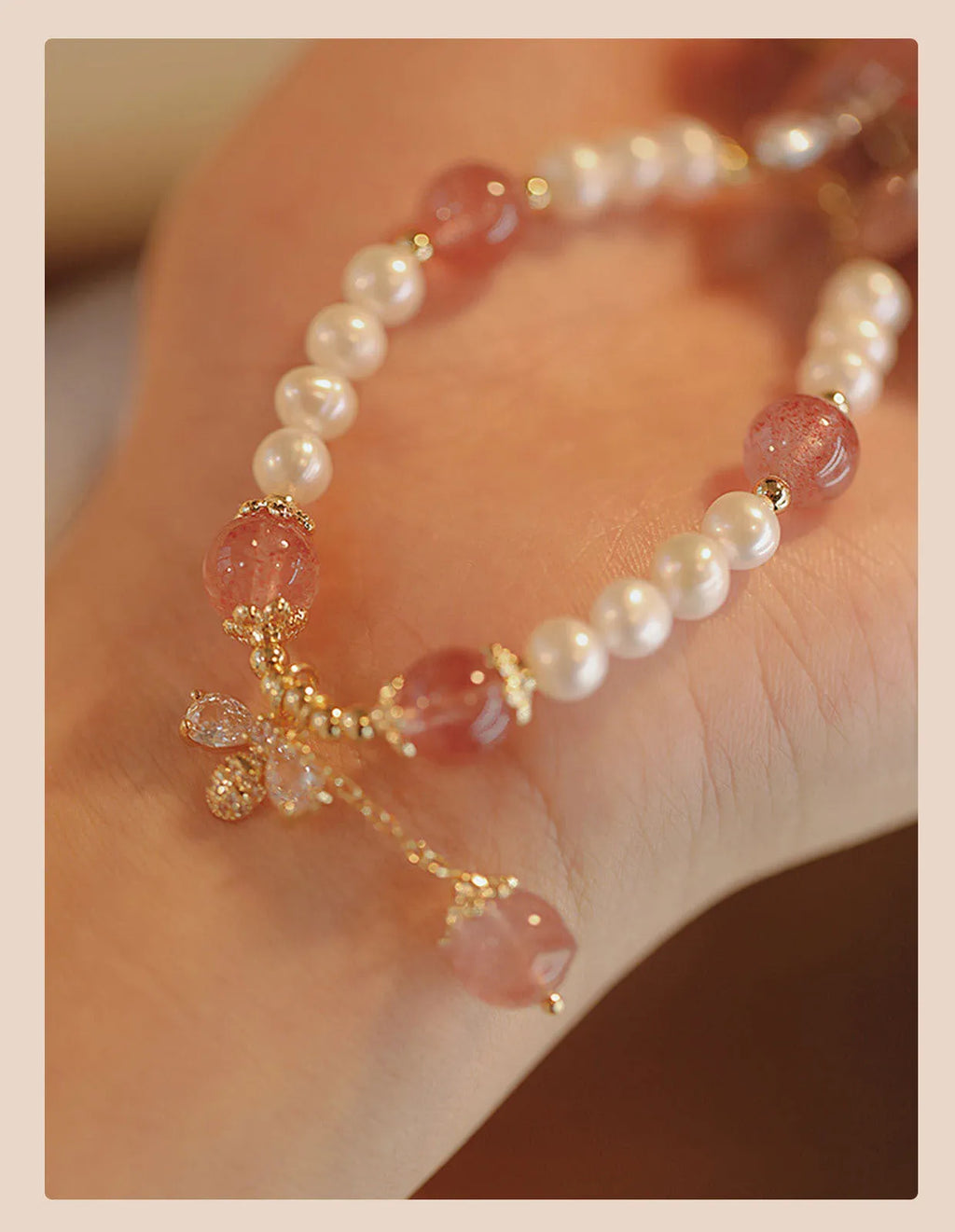 Women's strawberry quartz crystal bracelet with bow clasp closure on wrist