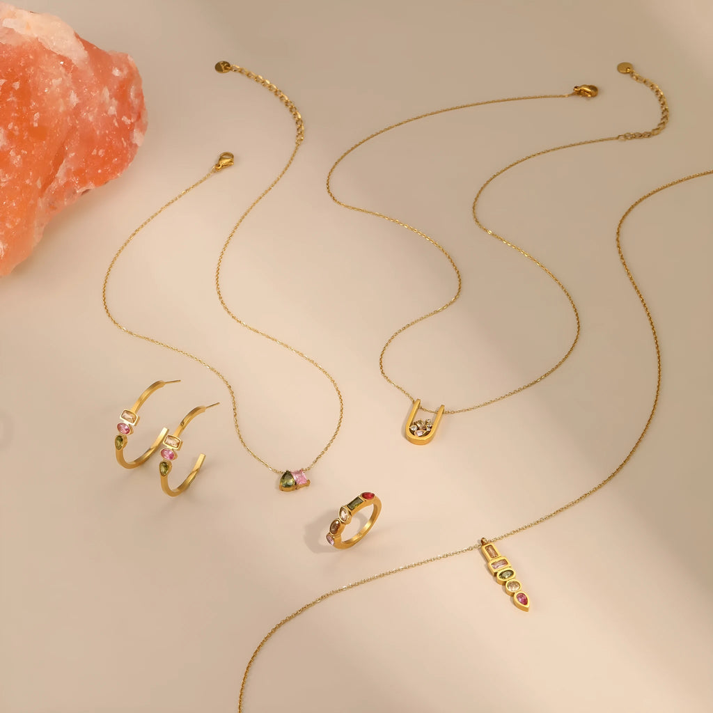 Geometric gold plated jewellery set showing necklace, ring and matching earrings with zircon detailing