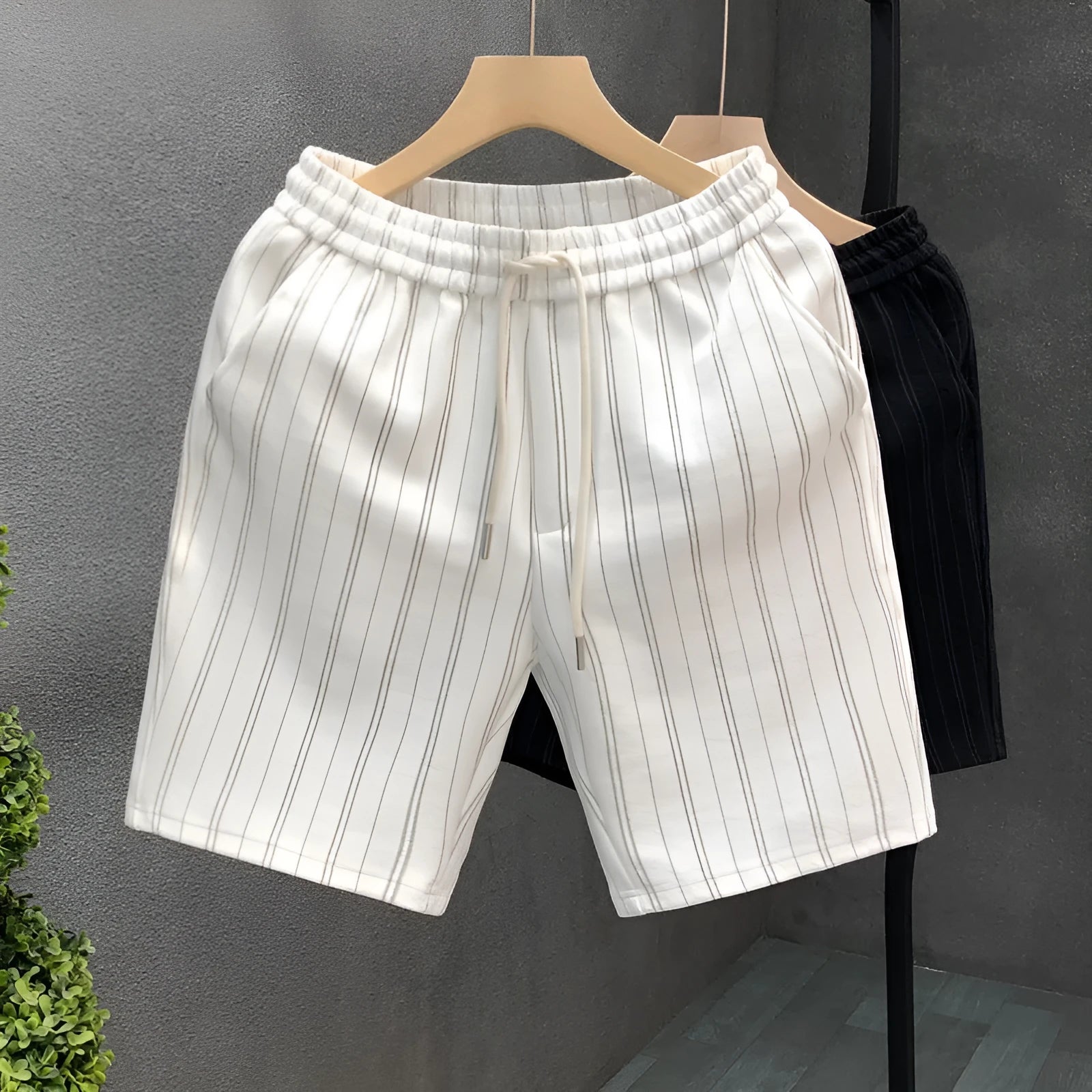 Men's black and white striped fleece-lined casual shorts with elastic waistband showing straight leg ankle banded design