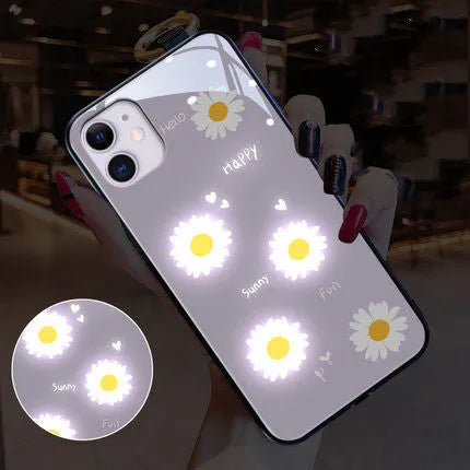 White iPhone case with painted purple daisies and lettering, illuminated with voice-activated colour-changing lights.