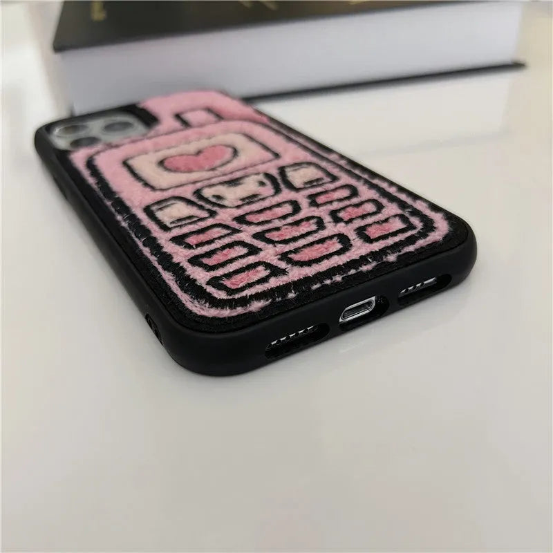 Pink iPhone back cover with a raised embroidered towel pattern design.