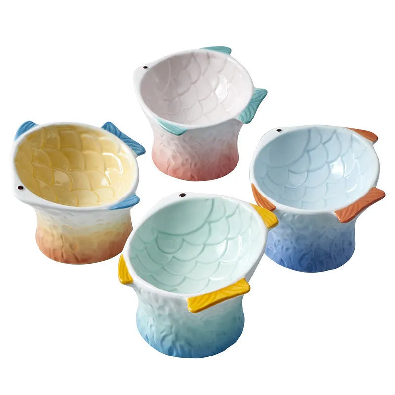 Blue fish-shaped ceramic cat bowl with 15-degree tilt angle on a wooden floor.