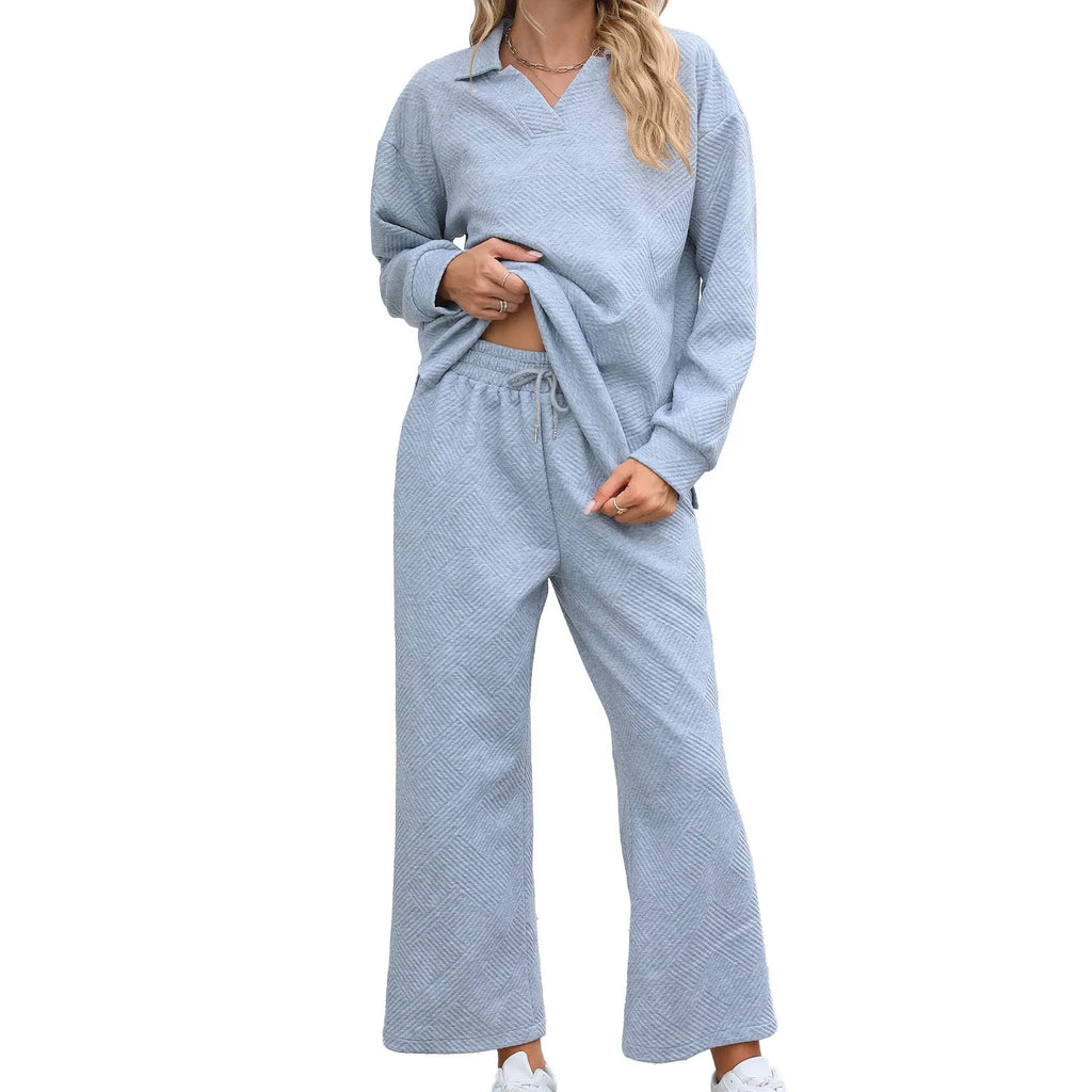 Women's black knitted jacquard two-piece suit with geometric pattern, showing long sleeve sweater and cropped elastic waist trousers.