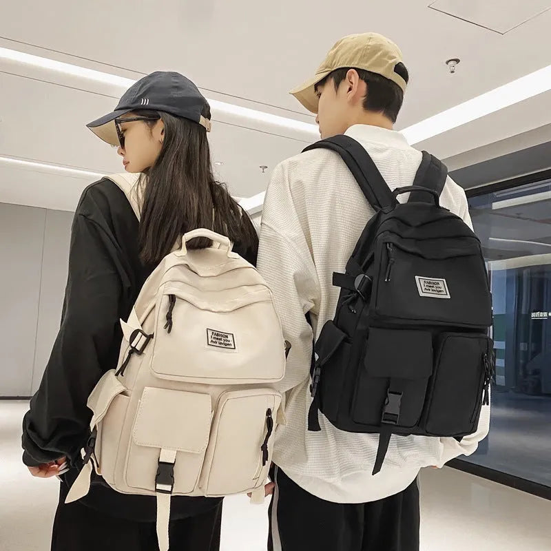 Black and white soft nylon student backpack with laptop compartment and external pockets.