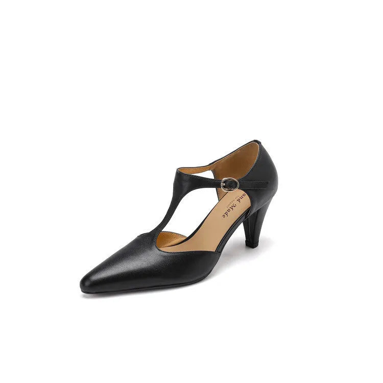Brown retro women's T-strap sandals with a closed round toe and a short stout heel on a wooden background.