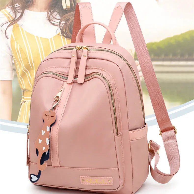 Black or pink women's casual nylon backpack with soft handle, showing internal zipper pockets and double shoulder straps.