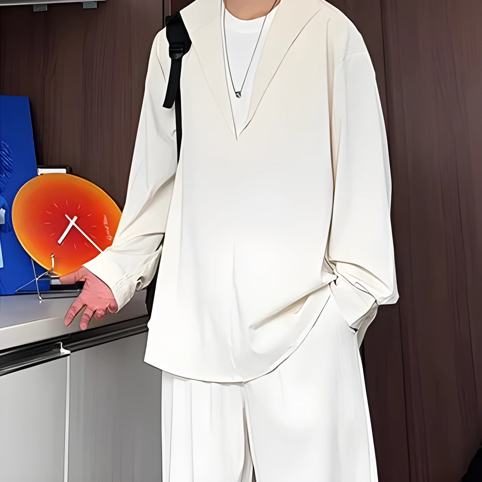 Men's apricot-coloured hemp-blend polo shirt and trousers two-piece casual suit on a hanger.
