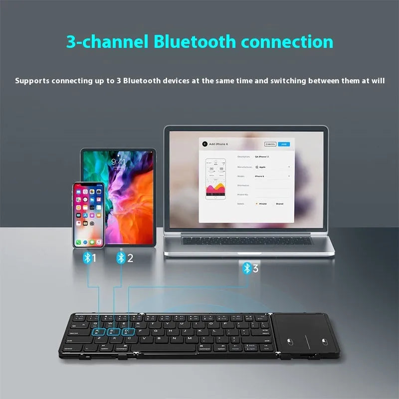 Black folding Bluetooth keyboard shown in open position next to mobile phone