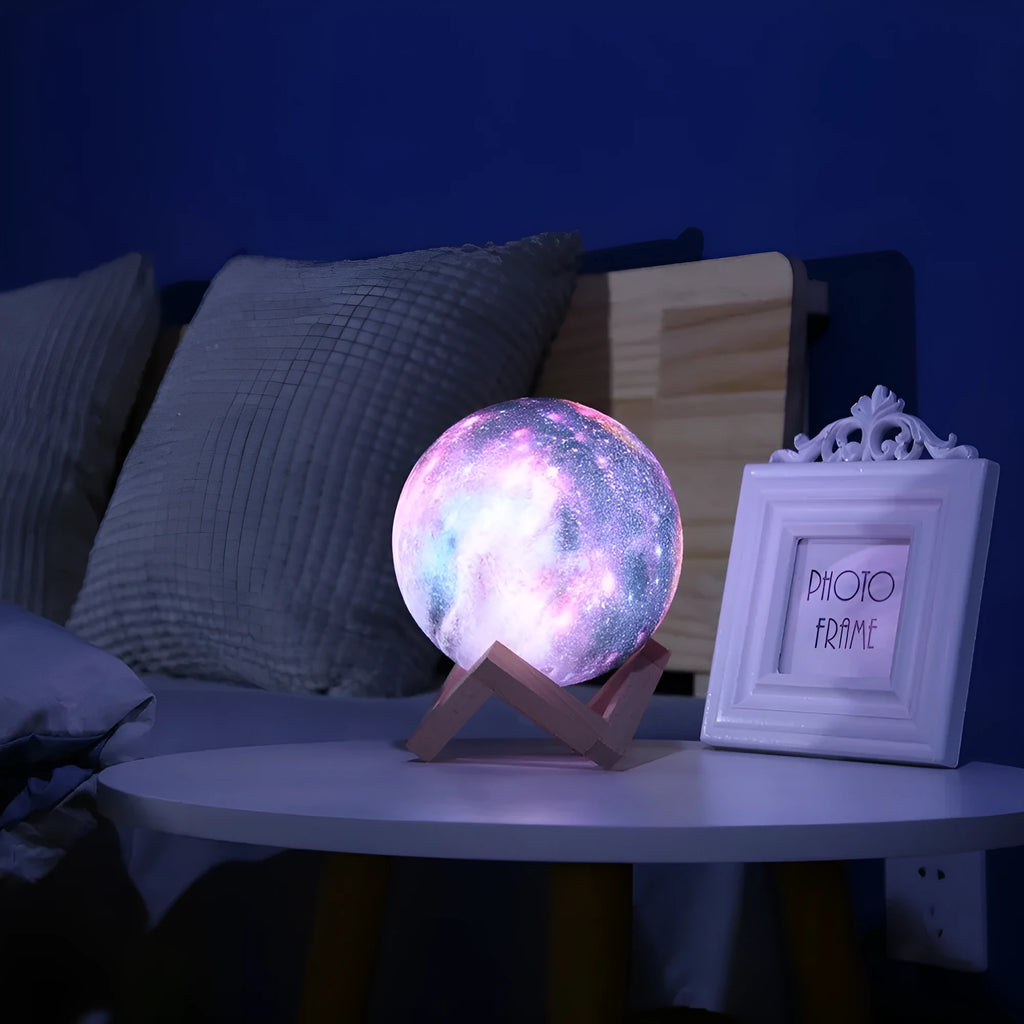3D printed spherical lunar night light on a table showing colour-changing LED illumination.