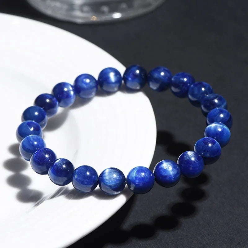 Polished blue crystal ball bracelet with geometric beads and Ruyi design on a white background.