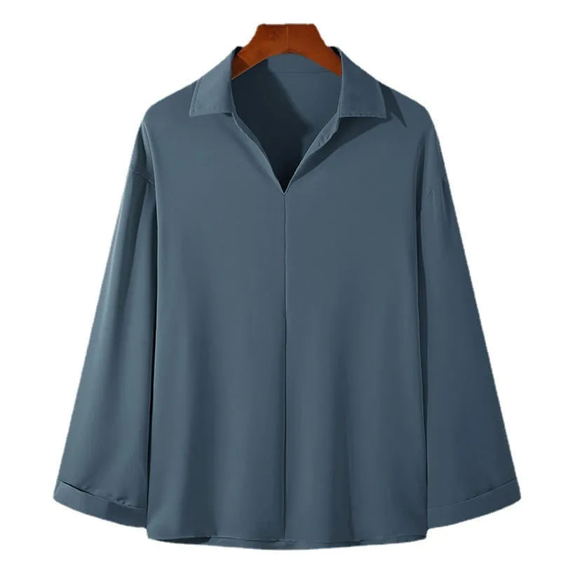 Man wearing a loose lapel, long sleeve casual shirt in a solid colour.