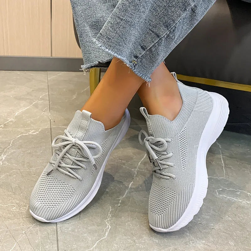 Women's mesh running shoes in creamy white with flat rubber sole and low-top design
