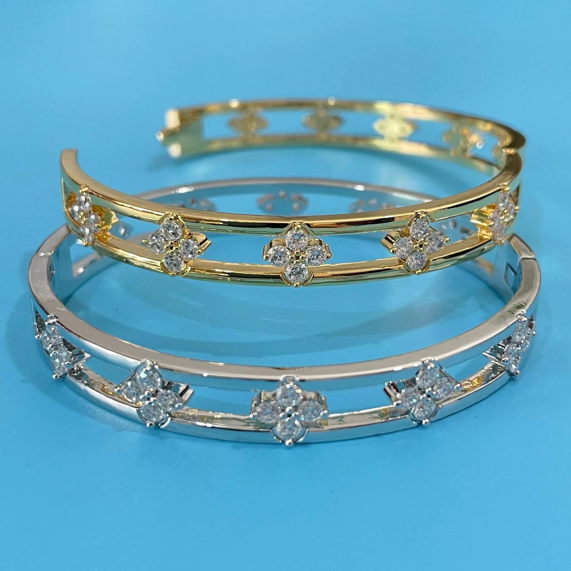 Gold or silver plated women's hollow bracelet with a four-leaf clover charm and zircon stones.