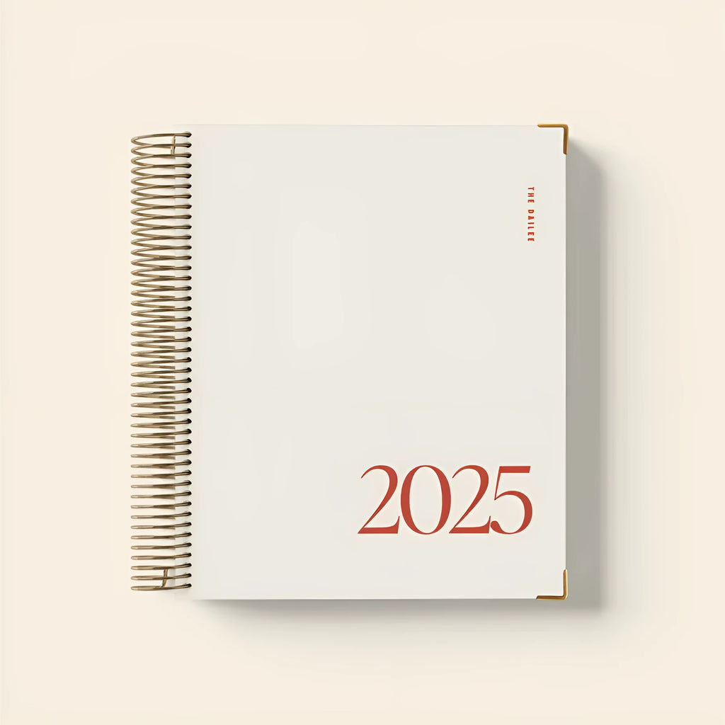 Cherry red coil notebook with daily schedule pages open showing weekly layout