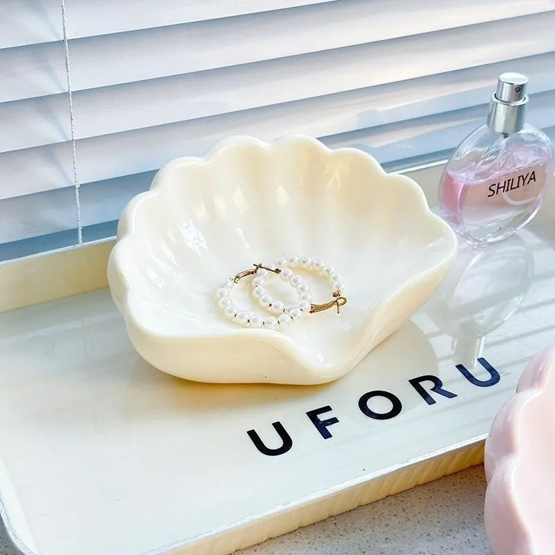 White and pink shell-shaped plastic soap dish for bathroom counter organisation.