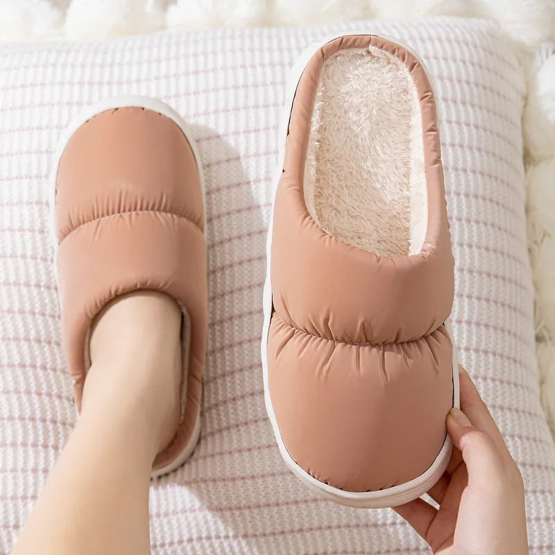 Pair of down cotton winter slippers with artificial leather upper, plush lining, and thick rubber sole.