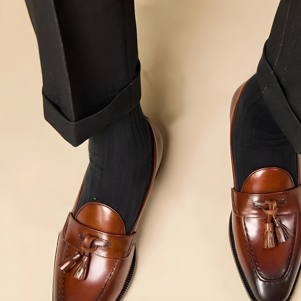 Men's black polished leather tassel loafers with a pigskin lining and rubber sole