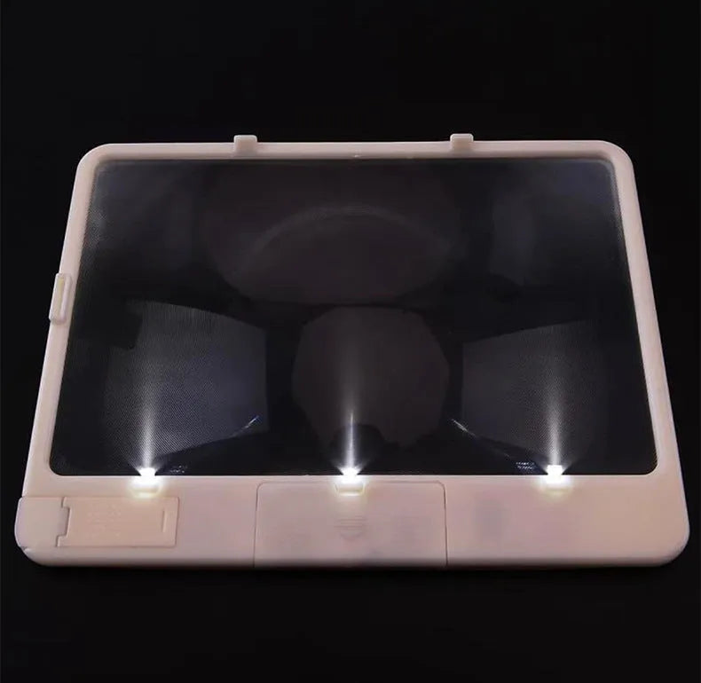Black and white LED magnifying glass with 3x lens on a desktop next to a book.