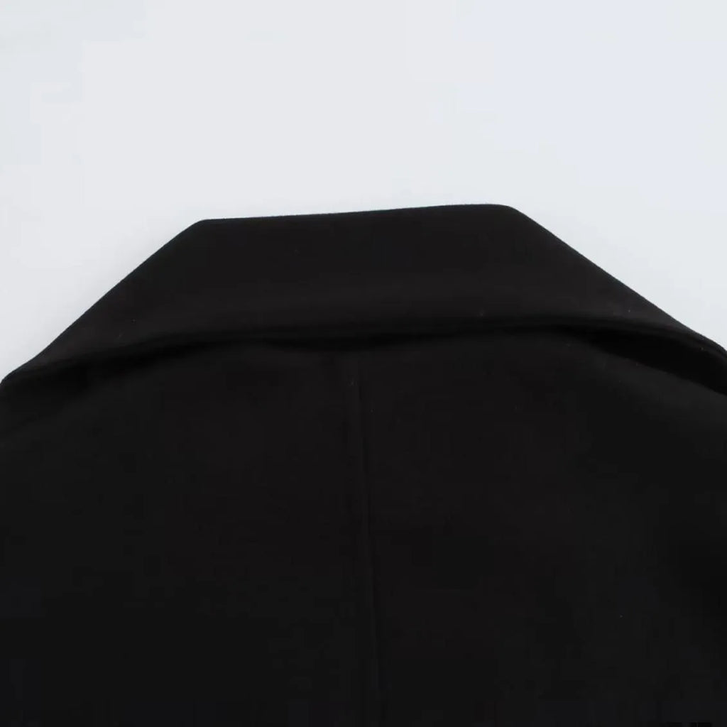 Women's long black overcoat with an artificial fur collar, shown with side pockets.