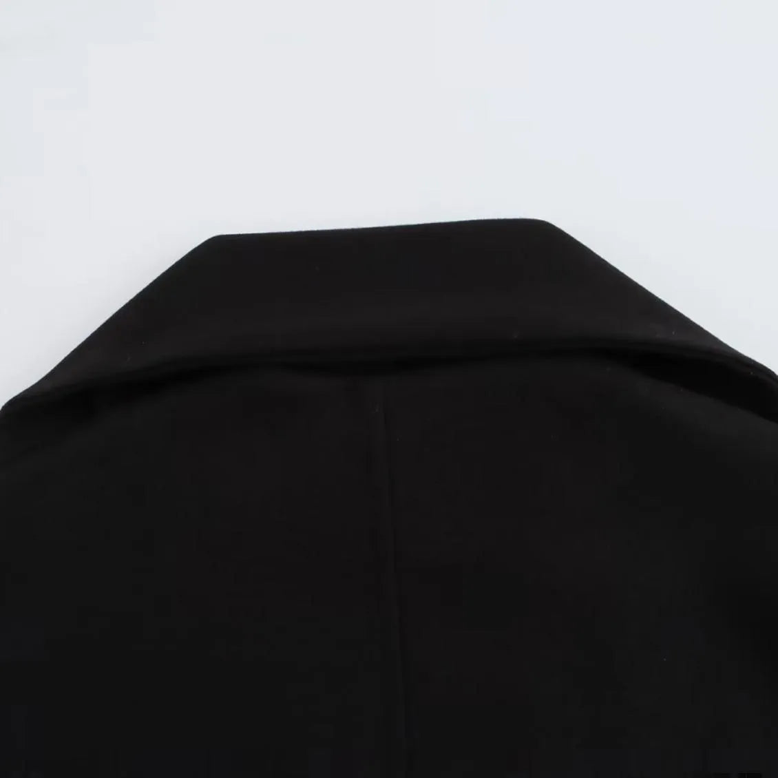 Women's long black overcoat with an artificial fur collar, shown with side pockets.