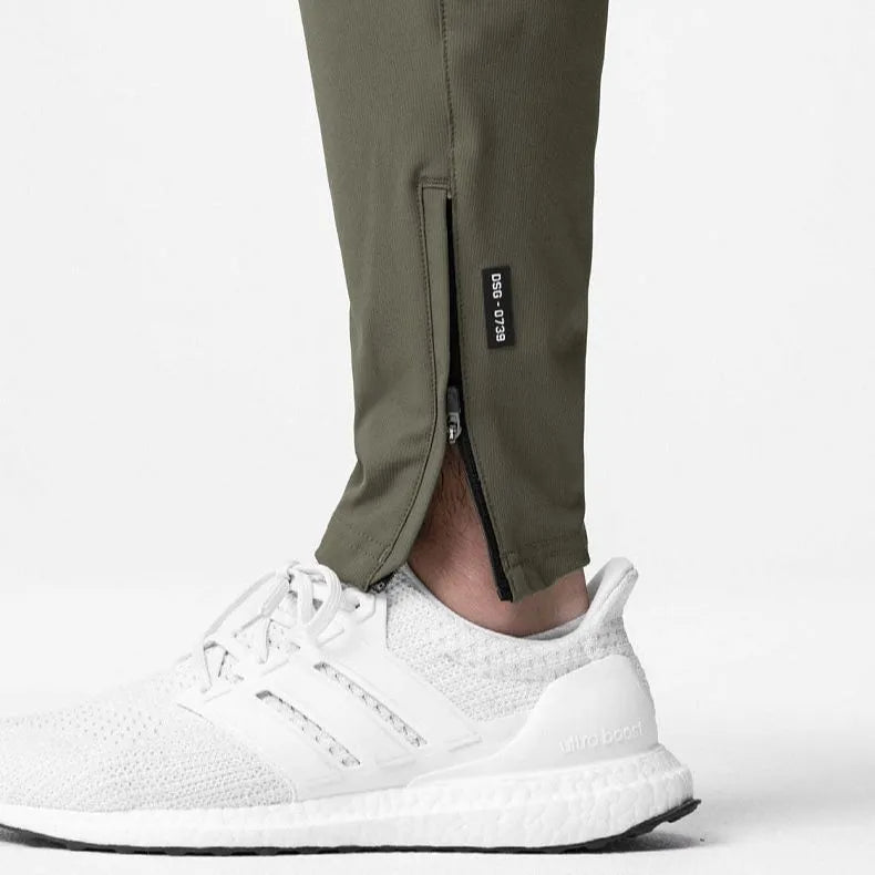 Men's ankle-tied loose fit running pants in a quick-dry fabric, shown in olive green colour.