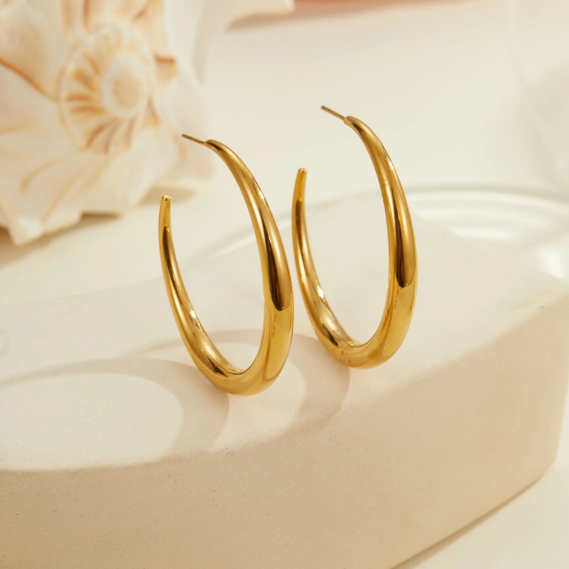 Simple round titanium steel hoop earrings for women in gold and steel finishes, shown in large and small sizes.