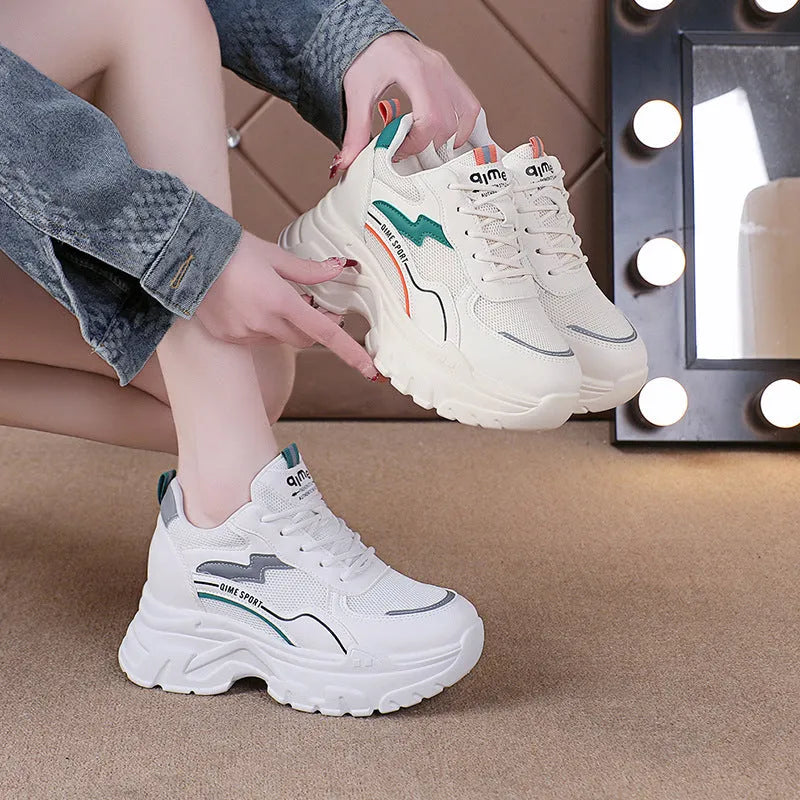 Women's white and beige low-top lace-up sports shoes with a breathable mesh upper.