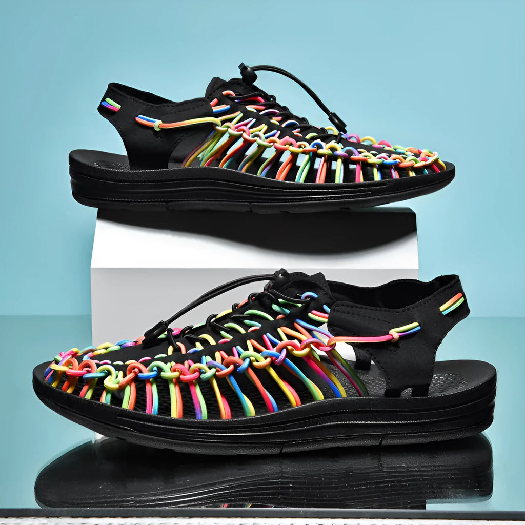 Casual woven sandals with drawstring tie closure in a rainbow colour pattern on a rubber sole.